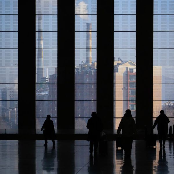 Silhouetted person stretching against a large window